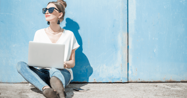 Mujer escribiendo copywriting en portátil al aire libre tomando el sol
