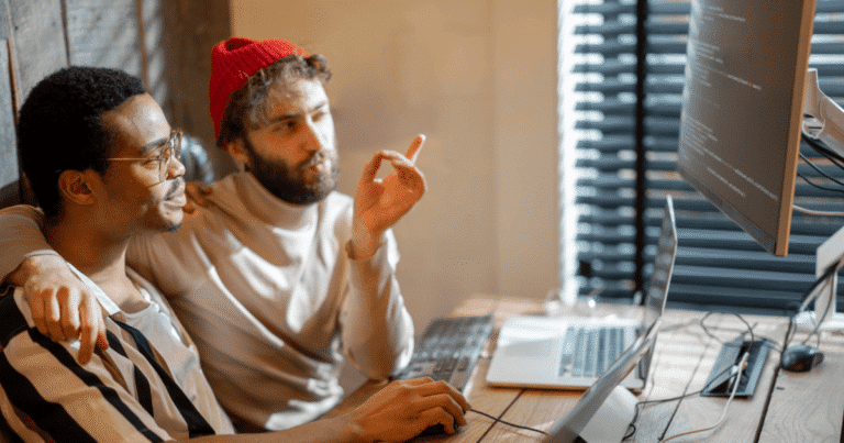 Dos chicos gays señalando un diseño web en el ordenador