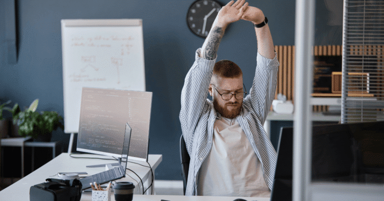 Hombre estirándose aliviado en la oficina tras optimizar los plugins