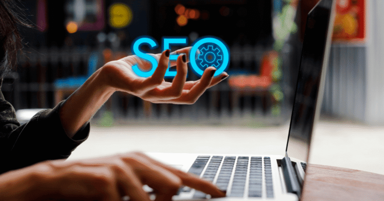 Primer plano de una profesional sosteniendo la palabra SEO con un engranaje en la letra O, mientras pulsa el teclado de su portátil. La imagen simboliza la unión entre la estrategia de una empresa de posicionamiento SEO y la ejecución técnica manual.